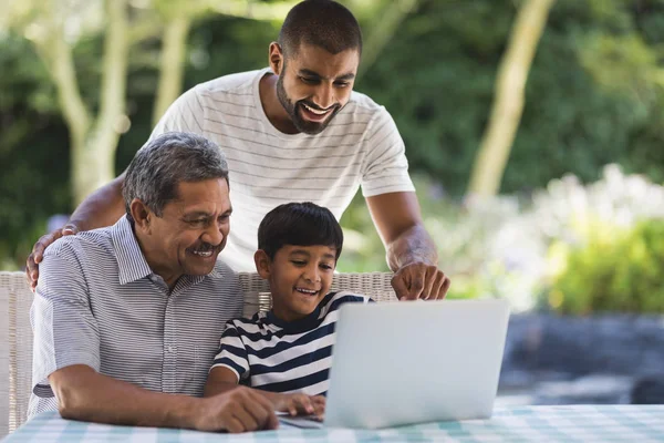 Πολλαπλών γενιάς οικογένεια χρησιμοποιώντας φορητό υπολογιστή στην βεράντα — Φωτογραφία Αρχείου