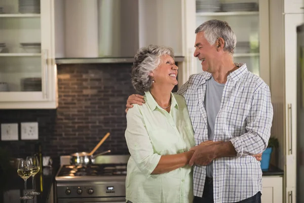 Äldre par embracing i kök — Stockfoto