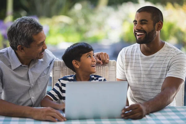 Família multi-geração sentada por laptop — Fotografia de Stock