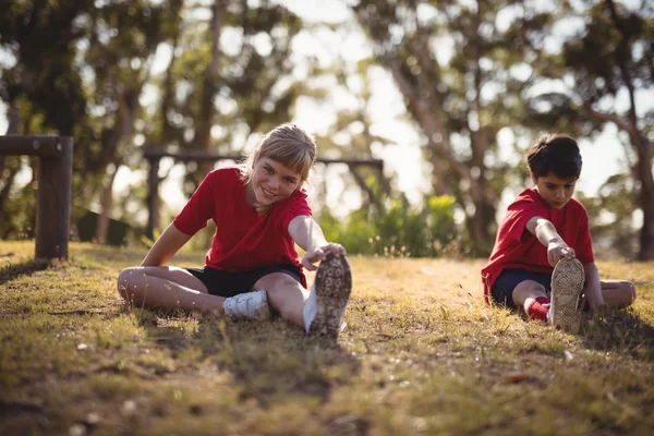 Crianças felizes realizando exercícios de alongamento — Fotografia de Stock