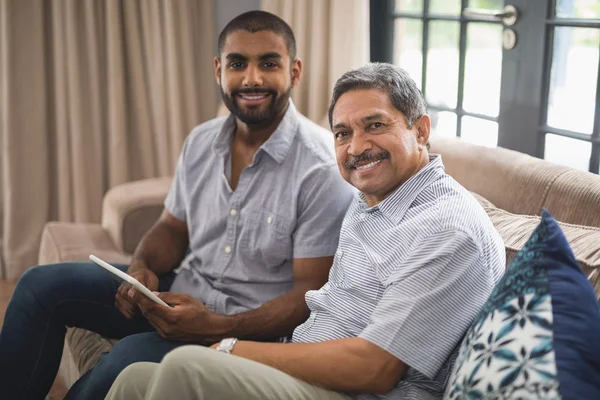 Чоловік з батьком сидить на дивані вдома — стокове фото
