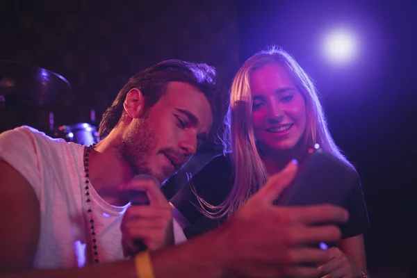 Musicians using mobile phone in nightclub — Stock Photo, Image