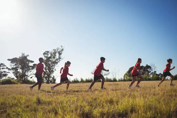 Niños corriendo en el campo de entrenamiento —  Fotos de Stock