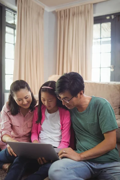 Семья использует ноутбук вместе в комнате — стоковое фото