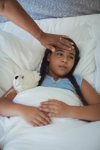 Grand-mère réconfortante petite-fille malade — Photo