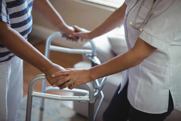 Médecin aidant la femme âgée à marcher avec marcheur — Photo