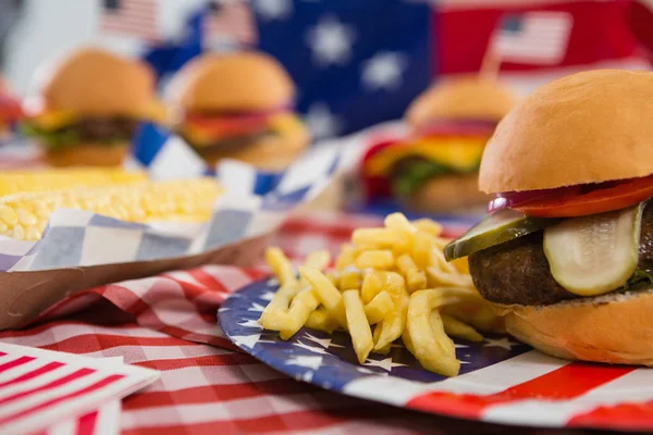 Hamburger a hranolky na desce — Stock fotografie