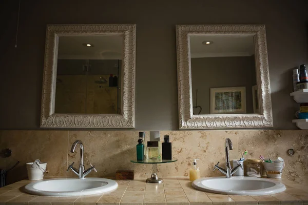 Mirrors hanging on wall by sink in bathroom — Stock Photo, Image