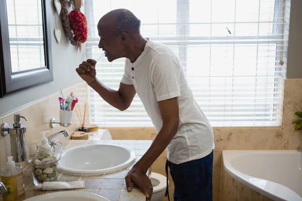 Ανώτερος άνθρωπος, βουρτσίζετε τα δόντια από το νεροχύτη στο μπάνιο — Φωτογραφία Αρχείου