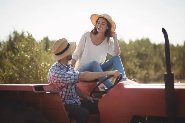 Пара сидящая вместе на тракторе — стоковое фото