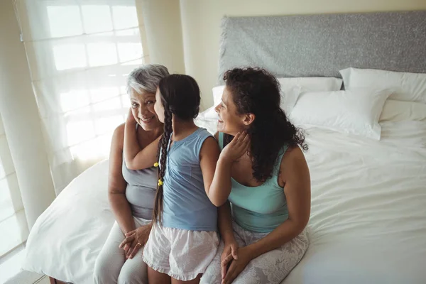 Daughter kissing grandmother on cheeks — Stock Photo, Image