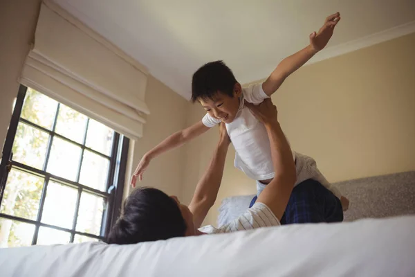 Vater spielt mit Sohn im Schlafzimmer — Stockfoto