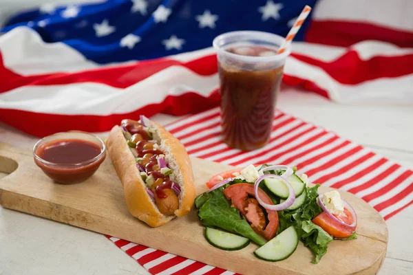 Американский флаг и хот-дог на столе — стоковое фото
