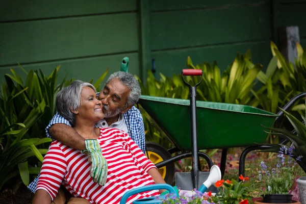 Hombre besar sonriente mujer en patio trasero — Foto de Stock