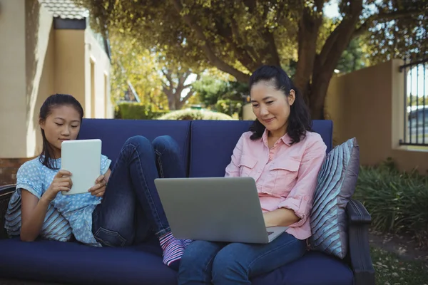 Mor och dotter med hjälp av Tablet PC och laptop — Stockfoto