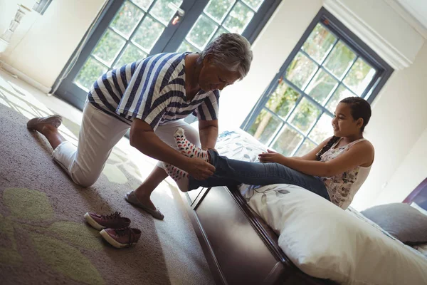 Mormor hjälper barnbarn att bära Strumpor — Stockfoto