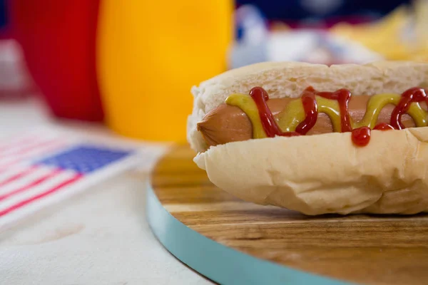 Bandera americana y perrito caliente en la mesa — Foto de Stock