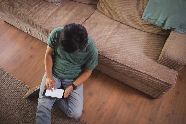Uomo che utilizza tablet digitale in salotto — Foto Stock