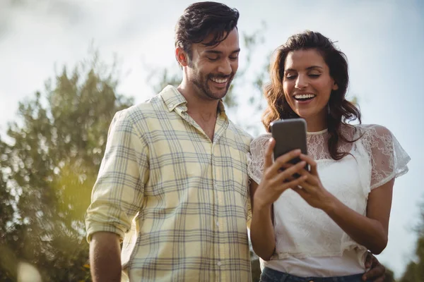 Couple utilisant le téléphone sur une journée ensoleillée à la ferme — Photo