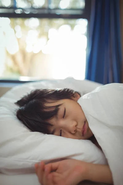 Menina dormindo na cama no quarto de cama — Fotografia de Stock