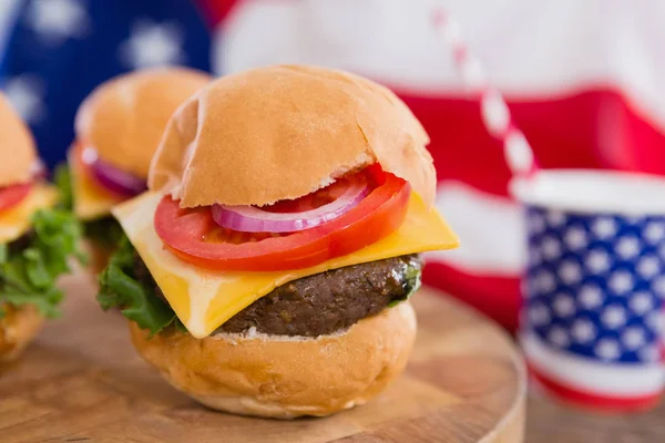 Bandera americana y hamburguesas en la mesa — Foto de Stock