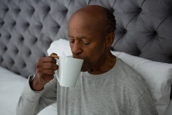 Senior man koffie drinken op bed — Stockfoto