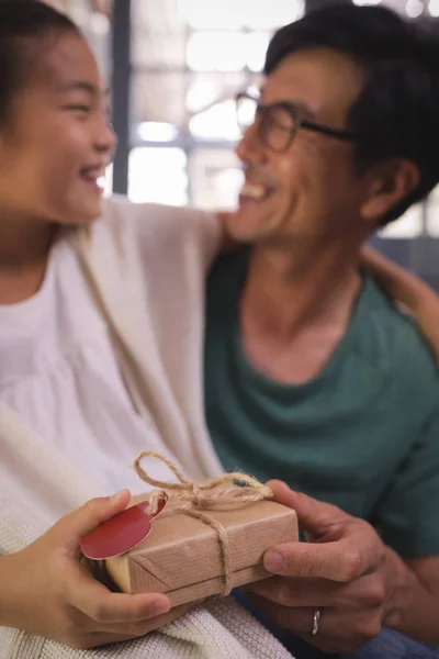 Dochter doos van de gift te geven aan de vader in de kamer — Stockfoto