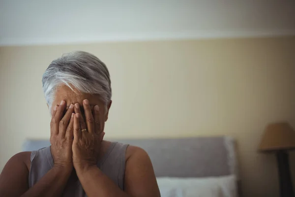 Старша жінка прикриває обличчя вдома — стокове фото