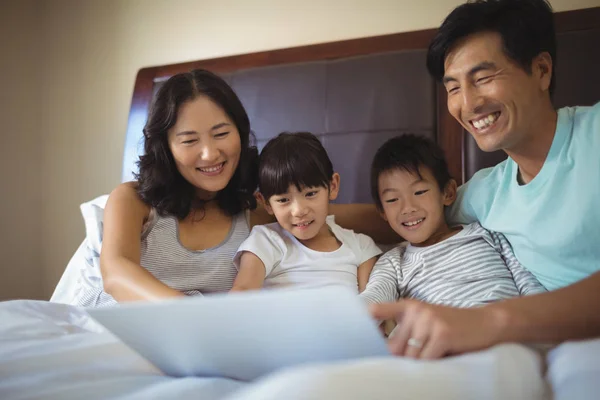 Famille utilisant un ordinateur portable ensemble dans la chambre — Photo