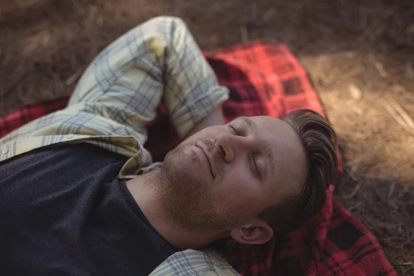 Hombre durmiendo en la alfombra en la granja — Foto de Stock