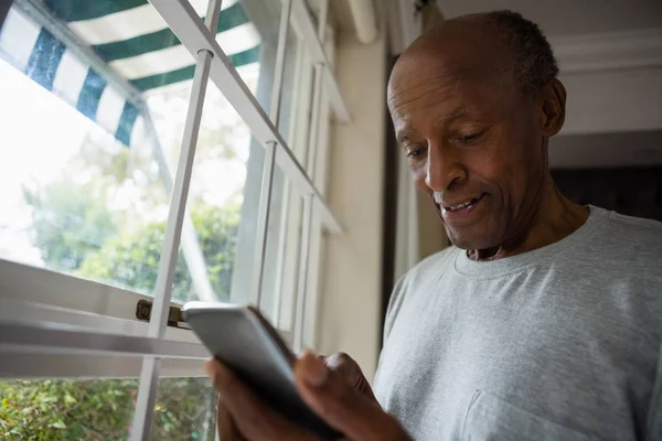 Senior benutzte Handy am Fenster — Stockfoto