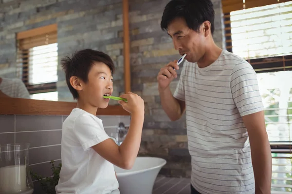Pai e filho escovando os dentes juntos — Fotografia de Stock