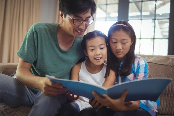 Father and siblings watching photo album together — Stock Photo, Image