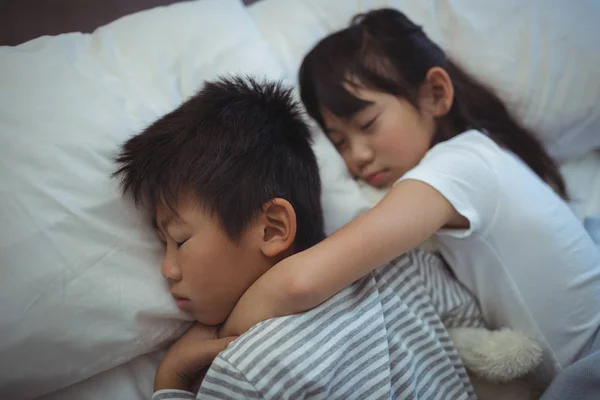 Rodzeństwo, spanie na łóżku w pokoju — Zdjęcie stockowe