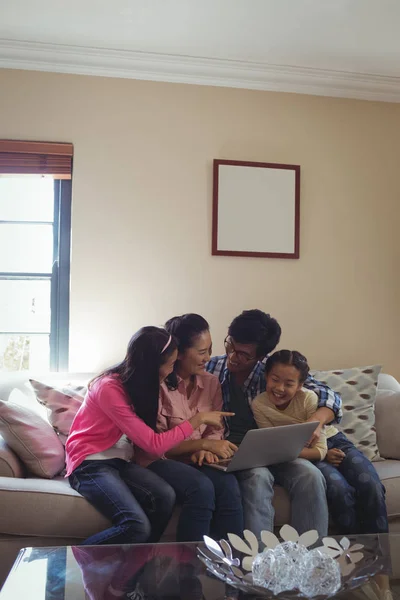 Familj med laptop tillsammans i vardagsrummet — Stockfoto