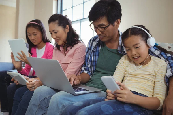 Familie met behulp van laptop, tablet en telefoon — Stockfoto