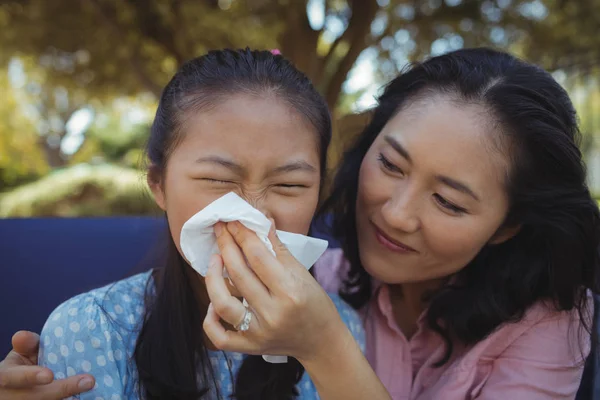 Mother helping daughter blow her nose — Stock Photo, Image