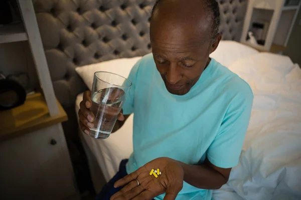 앉아있는 동안 약을 복용 하는 수석 남자 — 스톡 사진