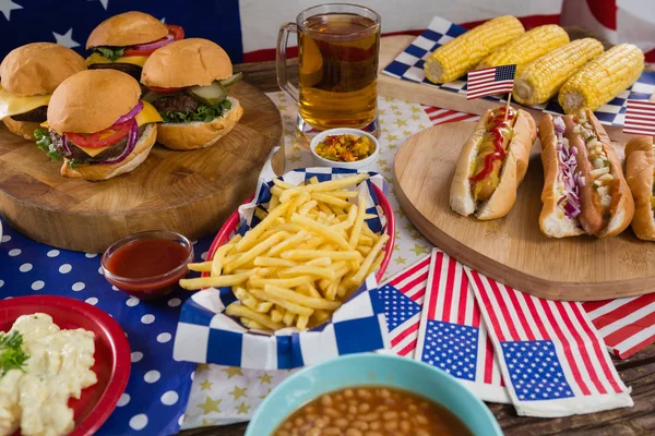 Párky v rohlíku a hamburgery na dřevěný stůl — Stock fotografie