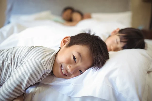 Irmãos dormindo na cama no quarto — Fotografia de Stock