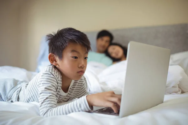 Boy using laptop in bedroom — Stock Photo, Image