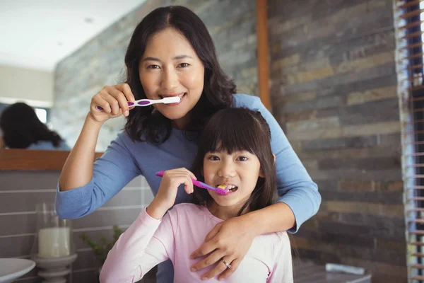 Mor och dotter borstar tänderna — Stockfoto