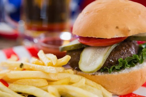 Hambúrguer e batatas fritas na mesa de madeira — Fotografia de Stock