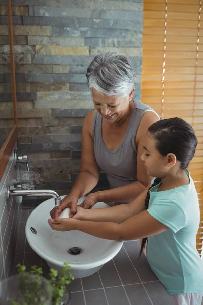 Бабушка и внучка моют руки — стоковое фото