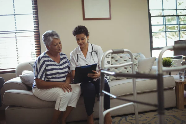 Médica interagindo com a mulher idosa — Fotografia de Stock