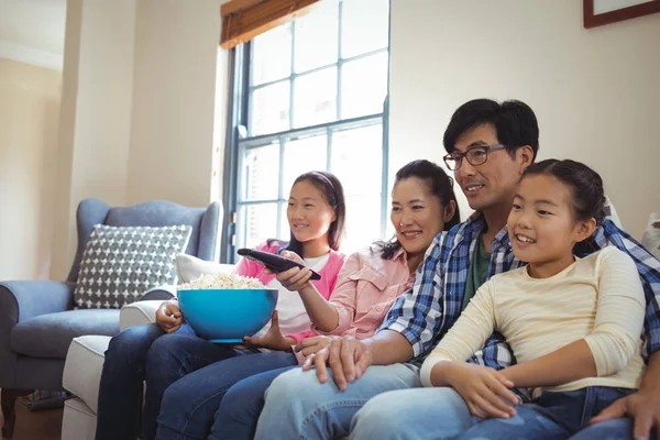 Улыбающаяся семья смотрит телевизор вместе — стоковое фото