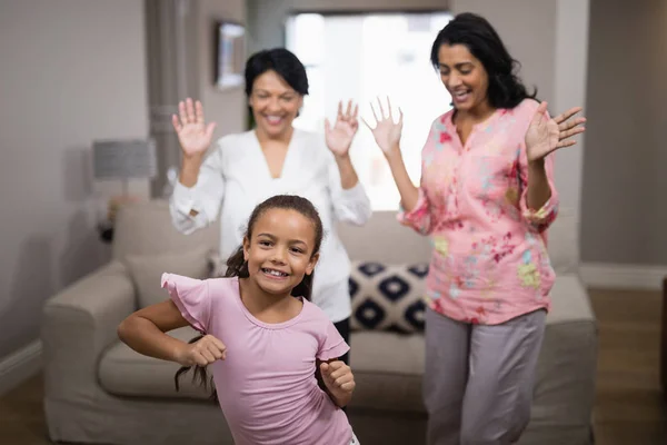Portret van lachende meisje dansen met familie — Stockfoto