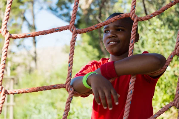 Boy leaning on net — Stock Photo, Image