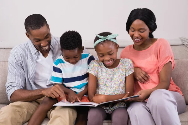 Familj läsa tidningen på soffa — Stockfoto