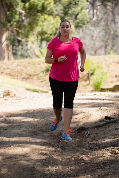 Mujer corriendo en el campo de entrenamiento — Foto de Stock